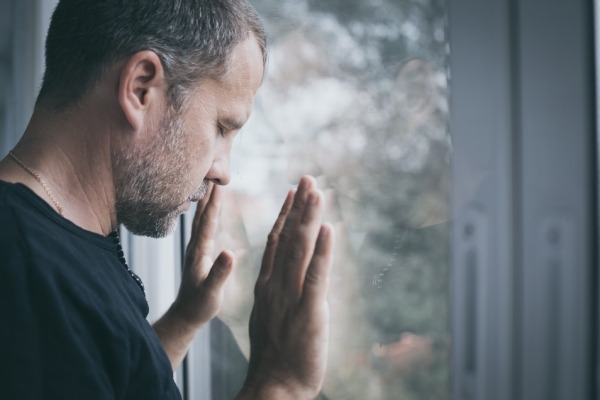 hombre con agorafobia mirando por la ventana